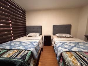 two beds sitting next to each other in a room at Chez Humbert in Santiago