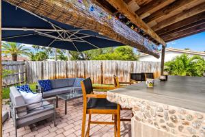 een patio met een tafel en stoelen en een parasol bij Nadios casa in Deerfield Beach