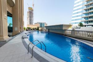 a large blue swimming pool in a building at Superhost Sea View Spacious 202 square meters apartment luxury property in Dubai