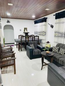 a living room with couches and a table and a projector at NEWCINNAMONVILLA in Habaraduwa