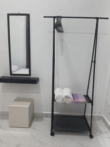 a bathroom with a rack with towels and a mirror at ZDH Homestay in Kota Bharu