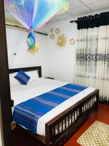 a bedroom with a bed with an umbrella on the wall at NEWCINNAMONVILLA in Habaraduwa