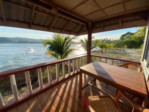 瓜隆島的住宿－Sok Sabay，阳台配有桌椅,享有水景。