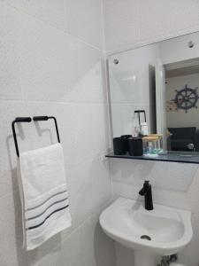 a white bathroom with a sink and a mirror at Rincón Marino in Sosúa