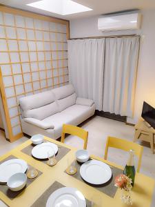 a living room with a couch and a table and chairs at R House 川越 in Kawagoe