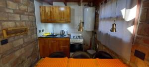 una pequeña cocina con fogones y fregadero en Cabañas km7 Bariloche en San Carlos de Bariloche