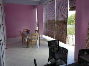 a dining room with purple walls and a table and chairs at Bois Gournable in Rodrigues Island