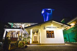 a building with a blue light on top at night at Monkey Island Hotel in Hikkaduwa