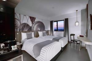 Un pat sau paturi într-o cameră la Hotel Neo Malioboro by ASTON