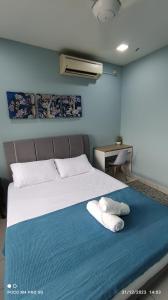 ein Schlafzimmer mit einem Bett mit zwei Handtüchern darauf in der Unterkunft Homestay Saujana Aster @ Putrajaya in Putrajaya