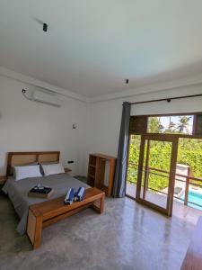 1 dormitorio con cama y mesa de madera en LoSu Polhena, en Polhena