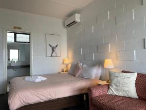KilcundaKilcunda Ocean View Motel的一间卧室，里面有一张床、一张沙发和一把椅子