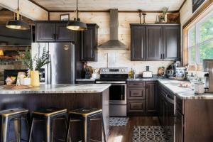 a kitchen with black cabinets and stainless steel appliances at Misty Mountain Cabin, Great Smoky Mountains in Sevierville