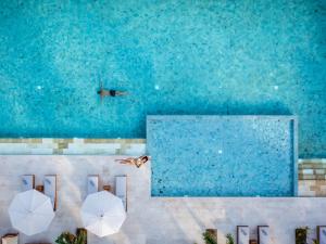 una vista aérea de una piscina con dos sombrillas en Cocana Resort Gili Trawangan en Gili Trawangan