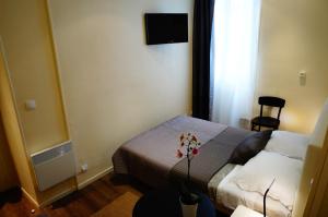 een hotelkamer met een bed en een televisie bij Hotel Zora in Parijs