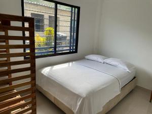 a bedroom with a bed and a window at La Casa de Ian in Santa Marta