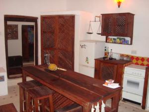 una cucina con un tavolo di legno in una stanza di Ella's Swahili House a Bagamoyo