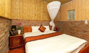 ein Schlafzimmer mit einem Bett und einer Ziegelwand in der Unterkunft Hoalu Backpacker Homestay in Ninh Bình