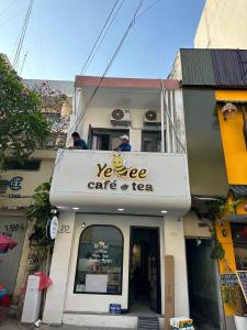 a sign for a vehicle car and tea on a building at 123 House with cinema room in District 1 in Ho Chi Minh City