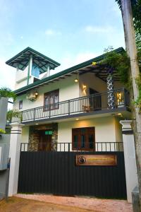 ein Haus mit einem schwarzen Zaun davor in der Unterkunft Monkey Island Hotel in Hikkaduwa