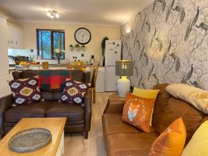 a living room with two couches and a kitchen at Lake District cottage in 1 acre gardens off M6 in Penrith