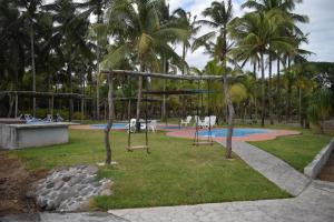 ein leerer Park mit einem Spielplatz mit Palmen in der Unterkunft Estancia Vacacional 20 Aguas in Ursulo Galván