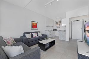 a living room with a couch and a table at Ocean View 1 bedroom Private Apartment next to Maroubra Beach in Sydney