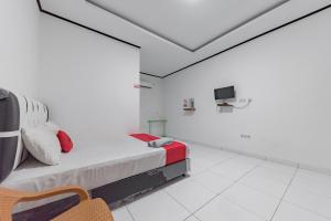 Una habitación blanca con una cama y un televisor. en RedDoorz @ Geopark Ciletuh Sukabumi, en Cilowa 19 fotos más