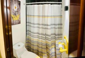 a bathroom with a shower curtain and a toilet at Hermoso Apartamento en Copan Ruinas in Copan Ruinas