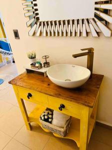 y baño con lavabo sobre una mesa de madera. en Hermoso Apartamento en Copan Ruinas, en Copan Ruinas