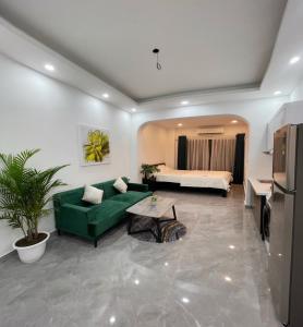 sala de estar con sofá verde y cama en Lami Homestay and Apartments, en Hanói