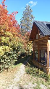 una cabaña de madera con un camino junto a algunos árboles en Cabañas km7 Bariloche en San Carlos de Bariloche