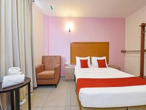 een hotelkamer met een bed en een stoel bij MRC Hotel Melaka Raya in Melaka