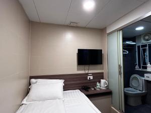 a hotel room with a bed and a flat screen tv at 香港星星旅馆 b&b in Hong Kong