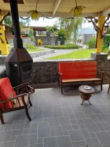 un patio al aire libre con fogones y 2 bancos en Le petit vignoble du brûlé marron, en Cilaos