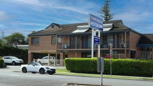 un panneau de rue devant une maison dans l'établissement Town Beach Motor Inn Port Macquarie, à Port Macquarie