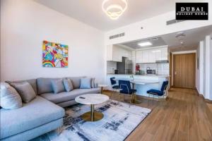 a living room with a couch and a table and a kitchen at 151 Residence Jumeirah Gardens in Dubai