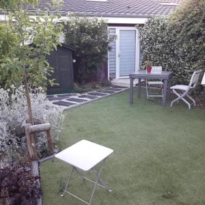 einen Garten mit einem Tisch und Stühlen im Gras in der Unterkunft l'annexe du jardin in Saint-Doulchard