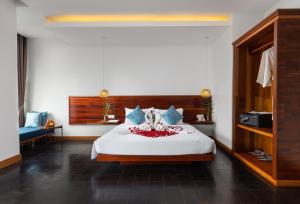 a bedroom with a large white bed with flowers on it at Khmer House Boutique in Siem Reap