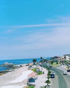 Una carretera junto a una playa con coches. en Departamento Frente al Mar, en Ilo