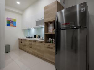 a kitchen with a stainless steel refrigerator and wooden cabinets at Yujing Nu Time in Yujing