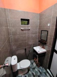a bathroom with a toilet and a sink at Roomstay Kak Ton in Kuala Terengganu