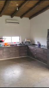 a large kitchen with wooden cabinets and a microwave at Casa Gande in San Fernando del Valle de Catamarca