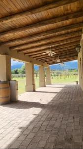 a patio with a wooden roof with a field in the background at Casa Gande in San Fernando del Valle de Catamarca