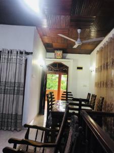 a dining room with chairs and a table and a ceiling at Delight Homestay in Ahangama