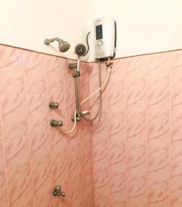uma casa de banho com um chuveiro e um telefone na parede em Delight Homestay em Ahangama