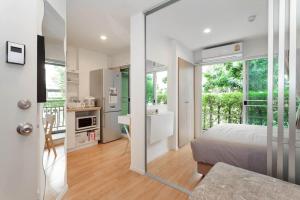 una camera con letto e una cucina con finestra di Fully Furnished Studio Apartments a Bangkok