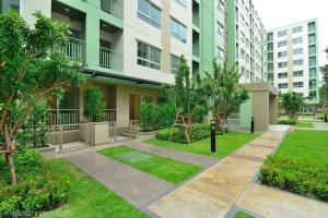 un cortile in un condominio con alberi e erba di Fully Furnished Studio Apartments a Bangkok