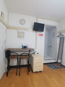 武蔵野市にあるgrori houseのテーブルと椅子2脚が備わる小さな客室です。