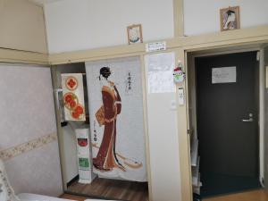 una habitación con una pintura de una mujer en la pared en grori house, en Musashino